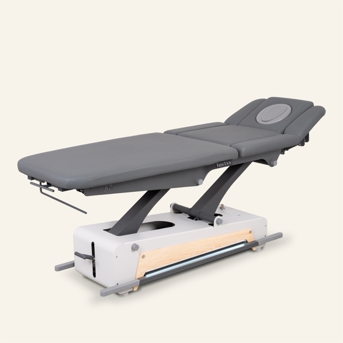 naggura SWOP 7 EVO Therapieliege in grau von schräg vorne mit hochgestelltem TWINLift-Kopfteil
